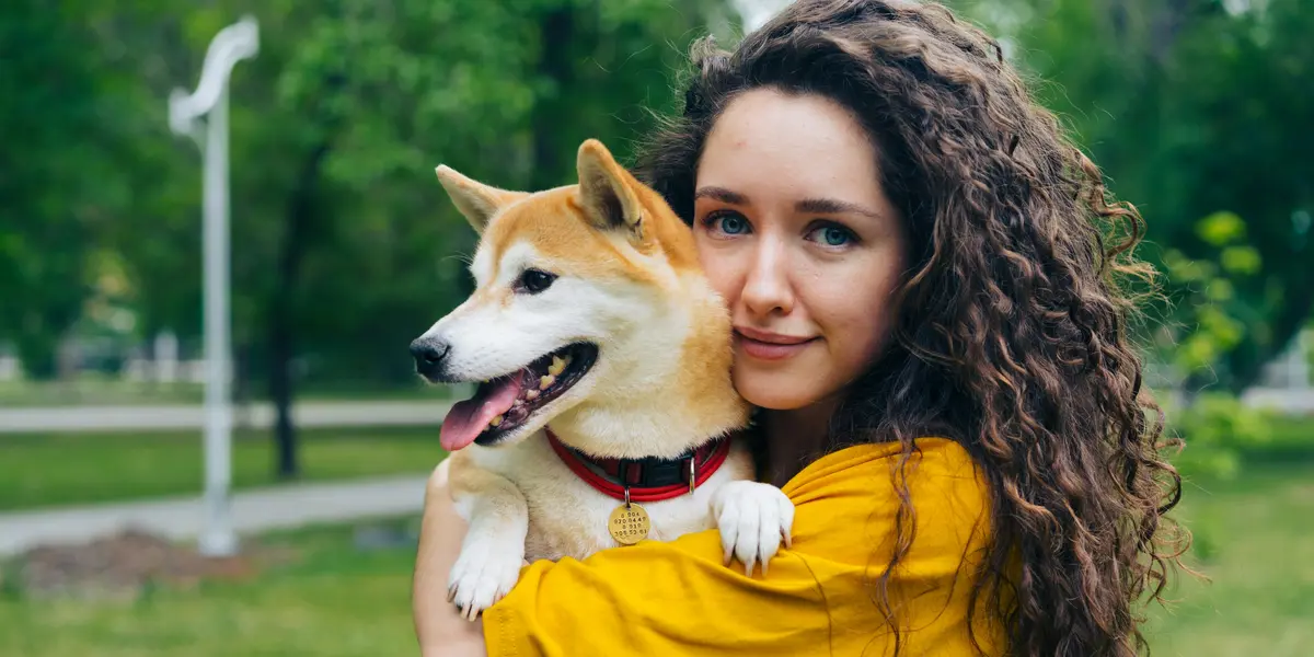 Frau mit Hund auf Arm